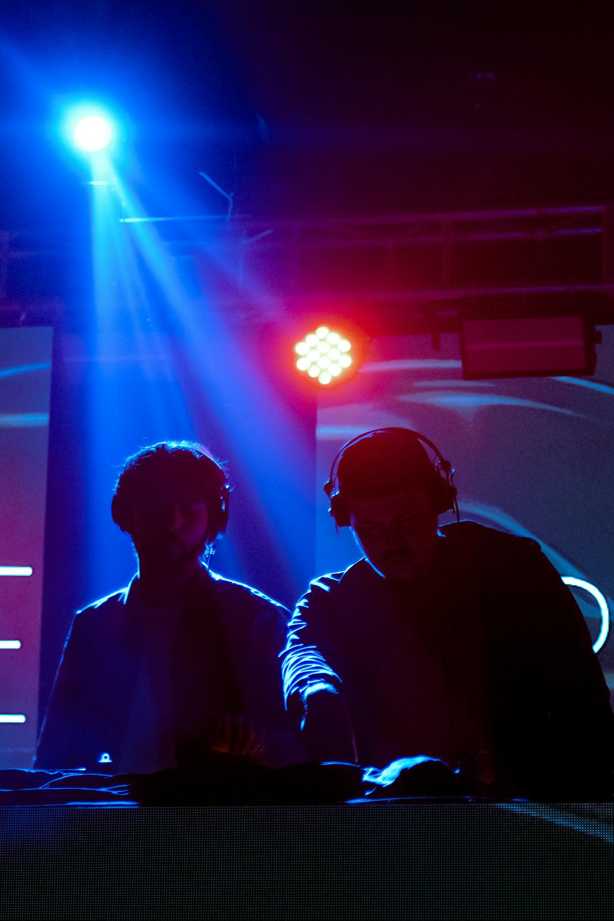 DJs working under blue and red venue lighting